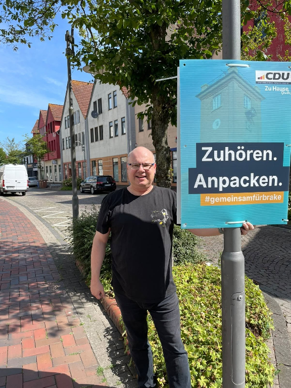 Claus Plachetka hängt ein CDU Plakat in Brake auf Claus Plachetka hängt ein CDU Plakat in Brake auf